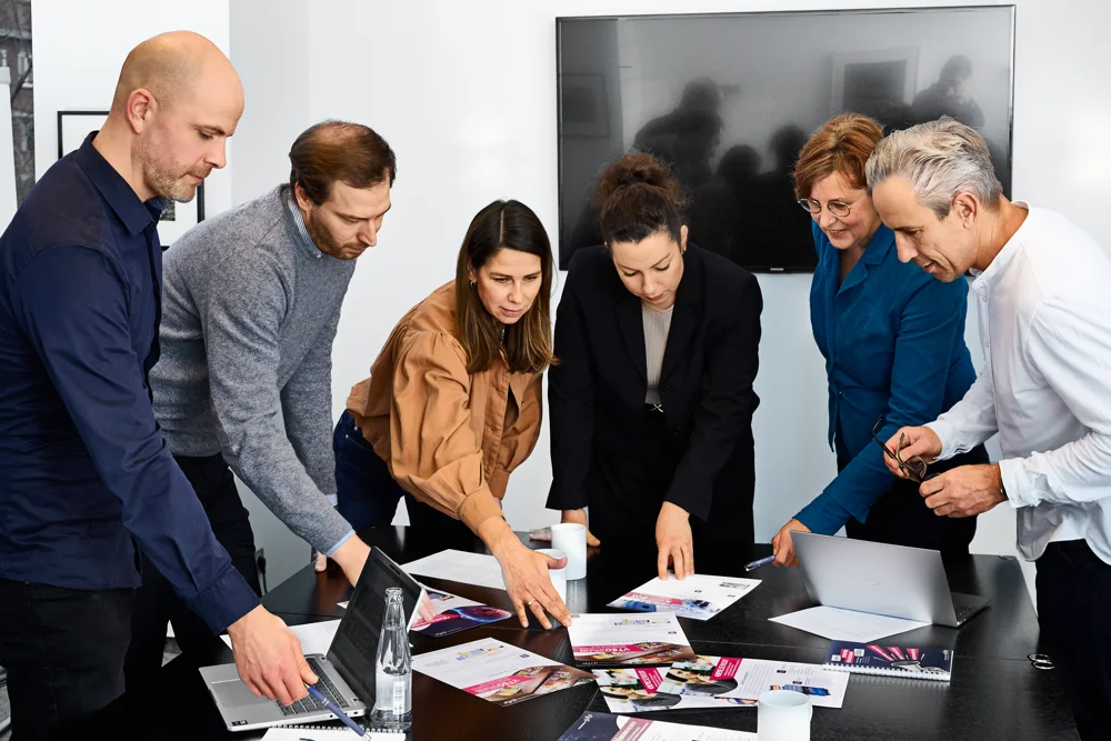 gdp_Shooting_10_12_2025_Arbeitssituation_große_Gruppe_am_Tisch_Labtop_Perspektive_4992